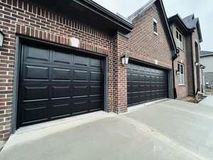 A traditional garage door with black panels.
