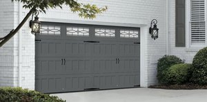 The Carriage Court garage door with gray panels and decorative glass inserts.